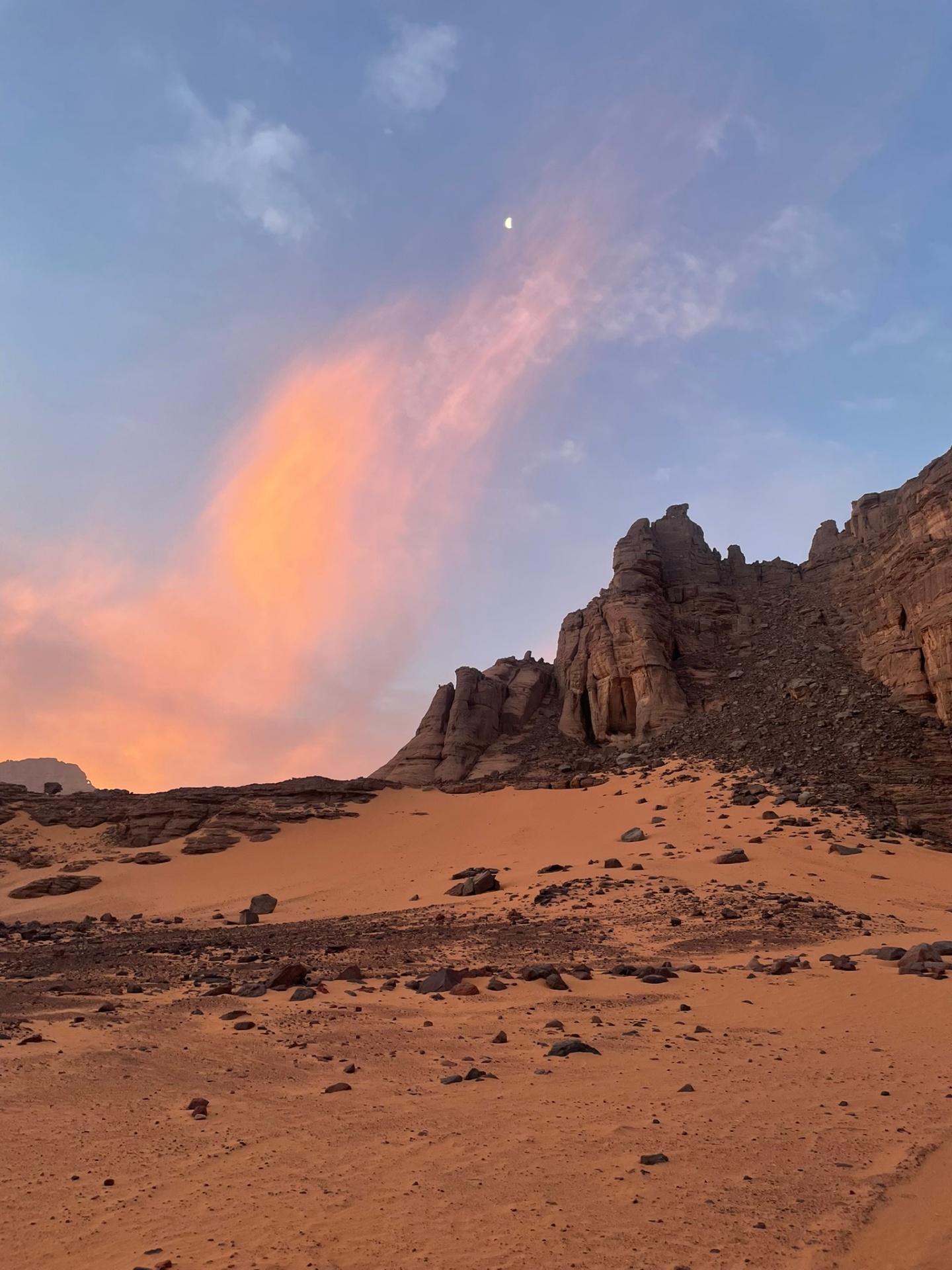 Falaises de grès et croissant de lune au crépuscule saharien